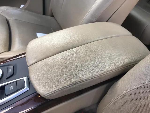 Przed renowacją: Podłokietnik w BMW X5 po czyszczeniu i odnowieniu jasnej skóry